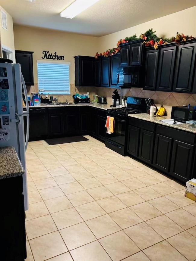Kitchen featuring dark cabinetry, black appliance