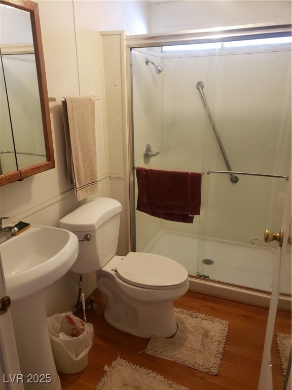 Bathroom featuring wood finished floors, a shower