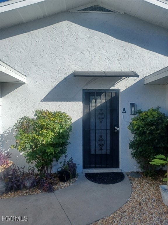 Entrance to property with stucco siding