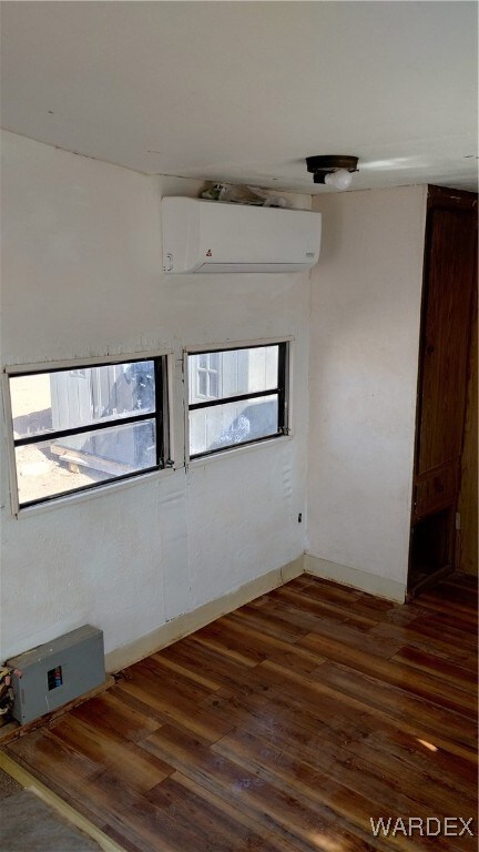 Unfurnished room with wood finished floors, a weal