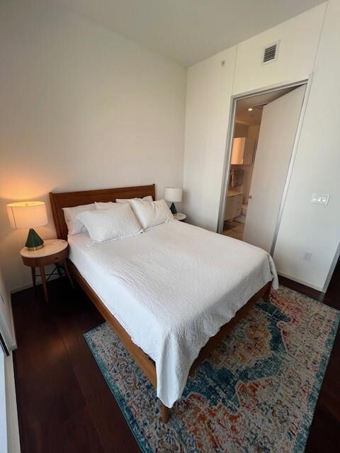 Bedroom with visible vents and wood finished floo