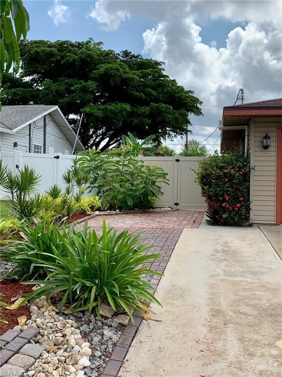 Pavers lead to side yard through vinyl fencing.