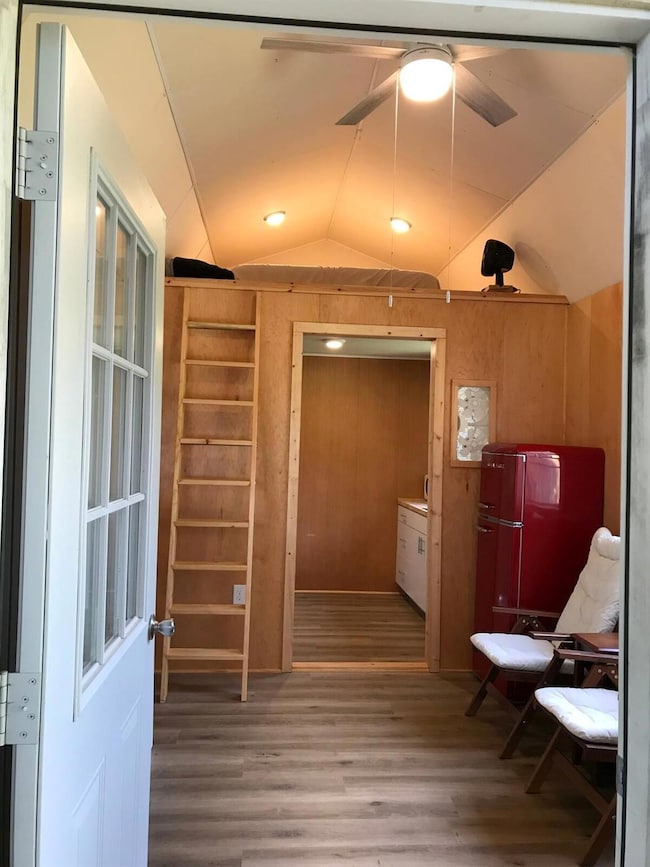 Hallway featuring vaulted ceiling, wood finished