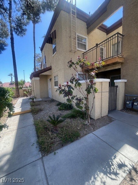 View of property exterior featuring a gate, stucco