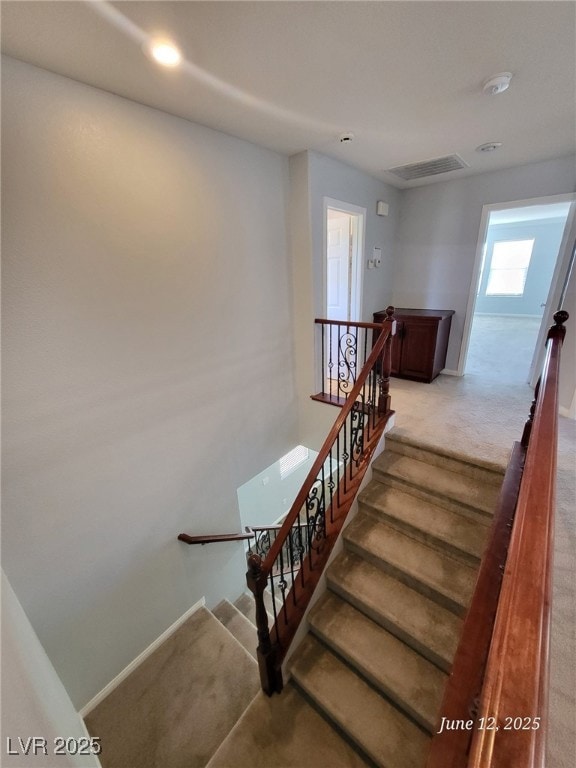 Stairway with carpet floors and recessed lighting