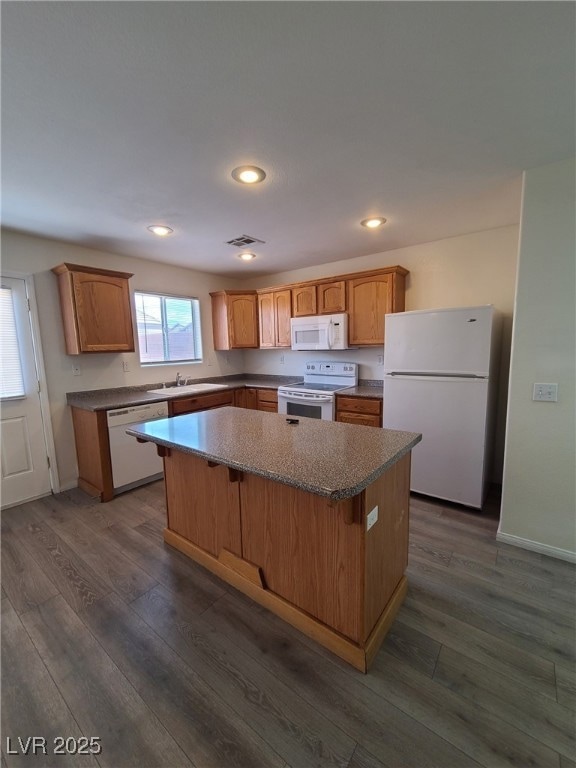 Kitchen with white appliances, a center island, a