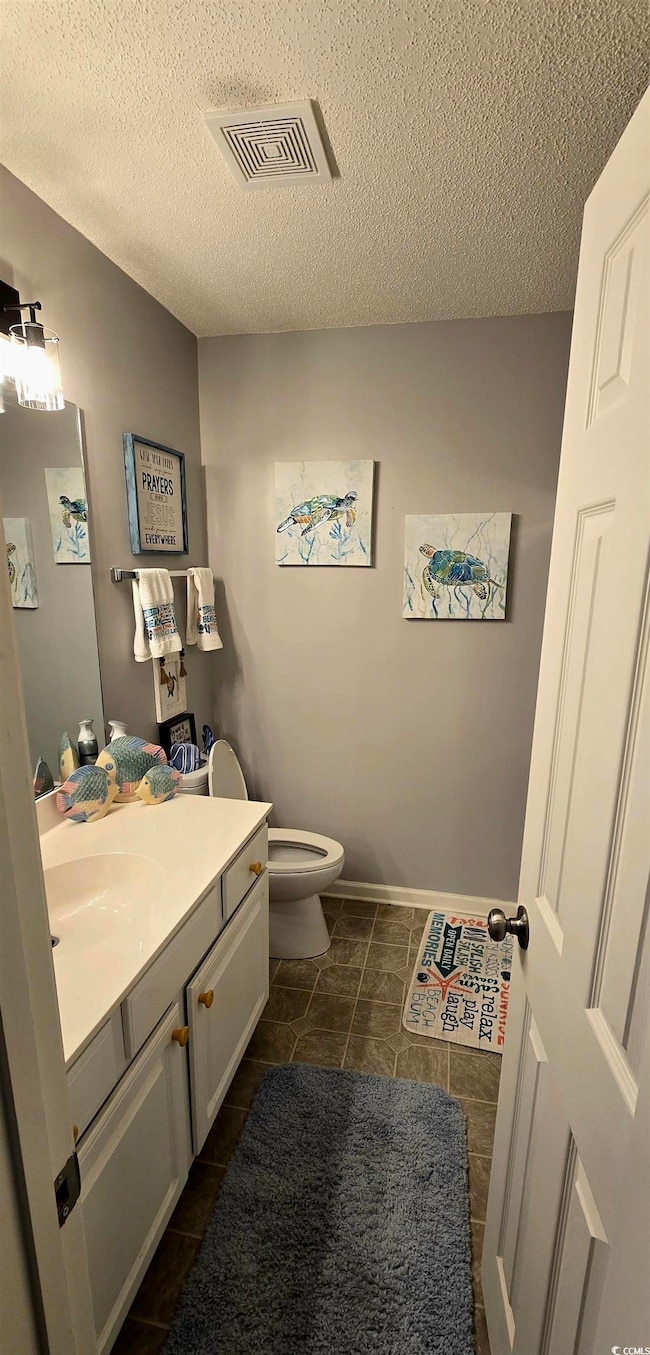 Bathroom with vanity, tile patterned floors, a tex