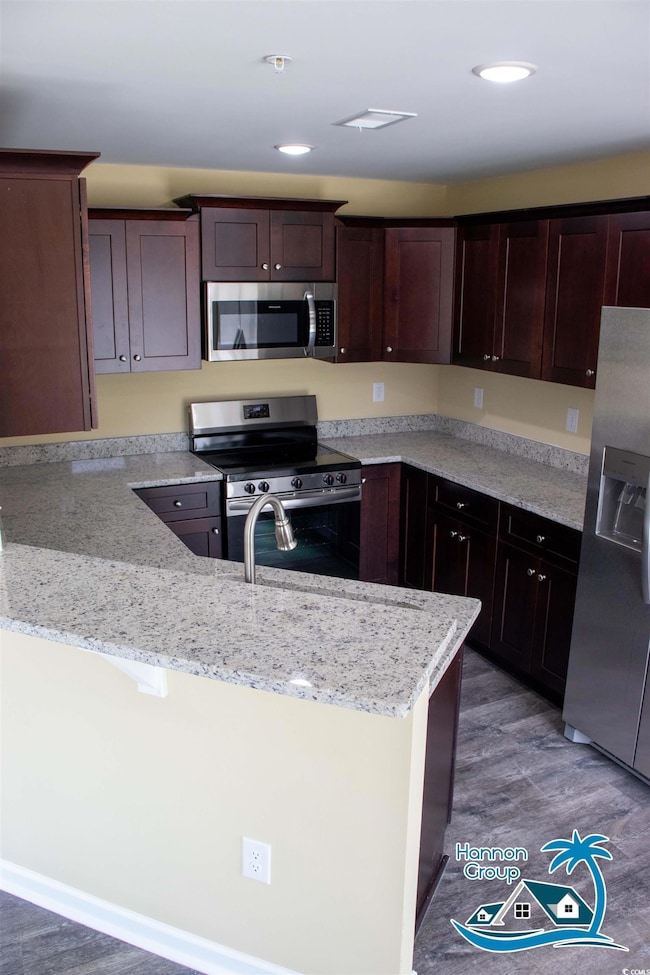 Kitchen featuring light stone counters, stainless 