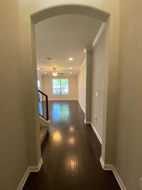 Hallway with dark wood-type flooring, arched walk