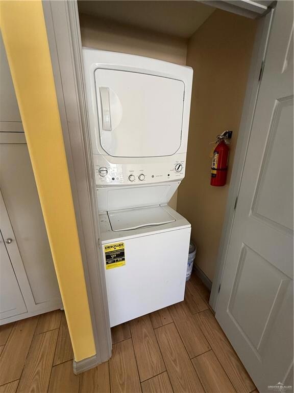 Laundry room featuring estacked washer and dryer and wood tiled floors