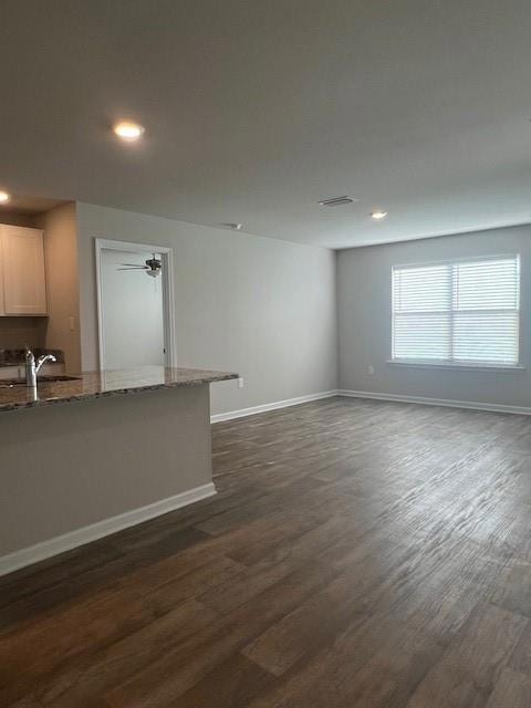 Unfurnished living room featuring recessed lighting and dark wood finished floors