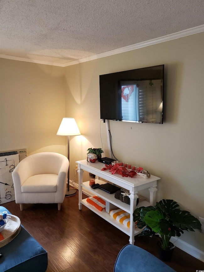 Living room featuring ornamental molding, dark har
