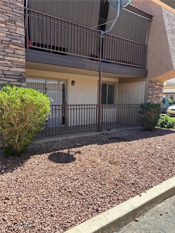 View of exterior entry with stucco siding, a balco