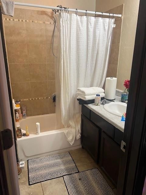 Full bath with shower / bath combination with curtain, vanity, tile patterned flooring, and a textured wall