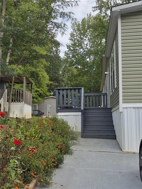Gate featuring a deck, view of scattered trees, and stairway
