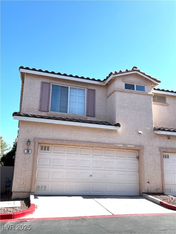 View of front of house with a garage, stucco sidin