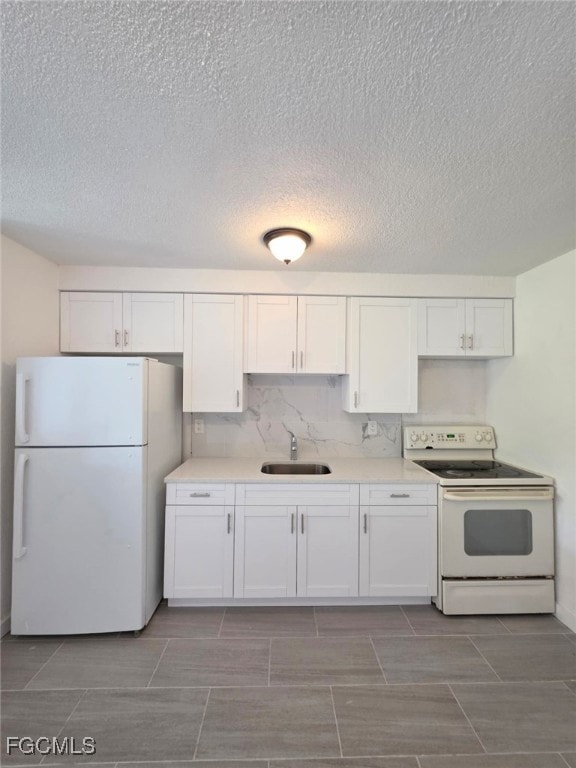 Kitchen featuring white appliances, white cabinets