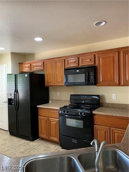 Kitchen featuring black appliances, brown cabinetr