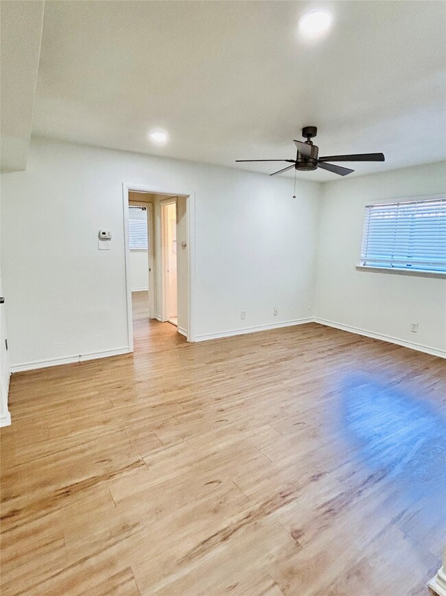 Spare room with light wood finished floors, recessed lighting, healthy amount of natural light, and ceiling fan
