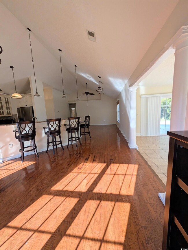 Interior space featuring dark wood-style flooring, ceiling fan, and vaulted ceiling