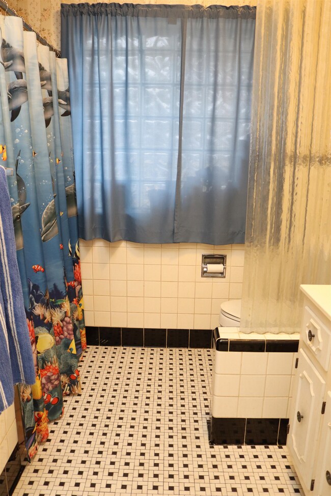 Bathroom with tile patterned floors, vanity, and a