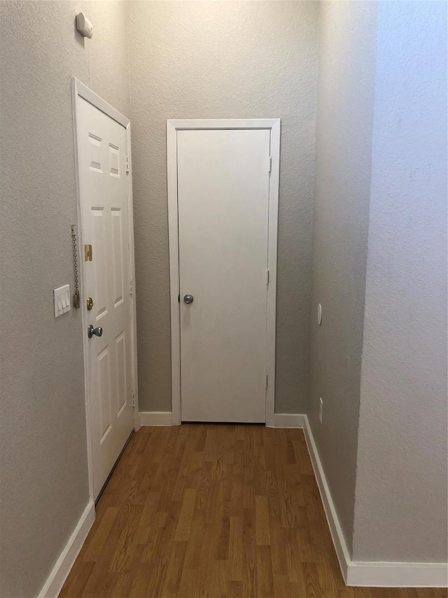 This view is the foyer with wood-type flooring.
