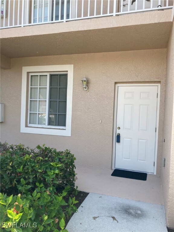 Property entrance featuring stucco siding