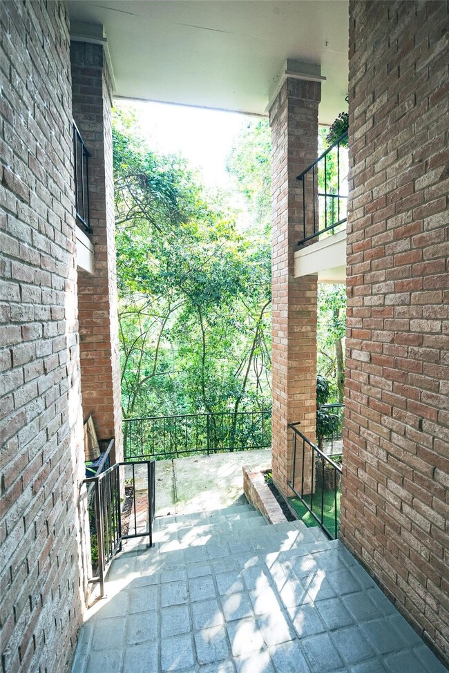 Stairway to Serene Views
As you ascend the stairs to the condo, you are greeted by a beautiful view of the bayou and surrounding lush greenery. The path is lined with brick pillars, and the natural landscape becomes even more prominent as you rise, offering a peaceful and scenic atmosphere. The sunlight filters through the trees, creating a serene and welcoming ambiance as you make your way to the condo.