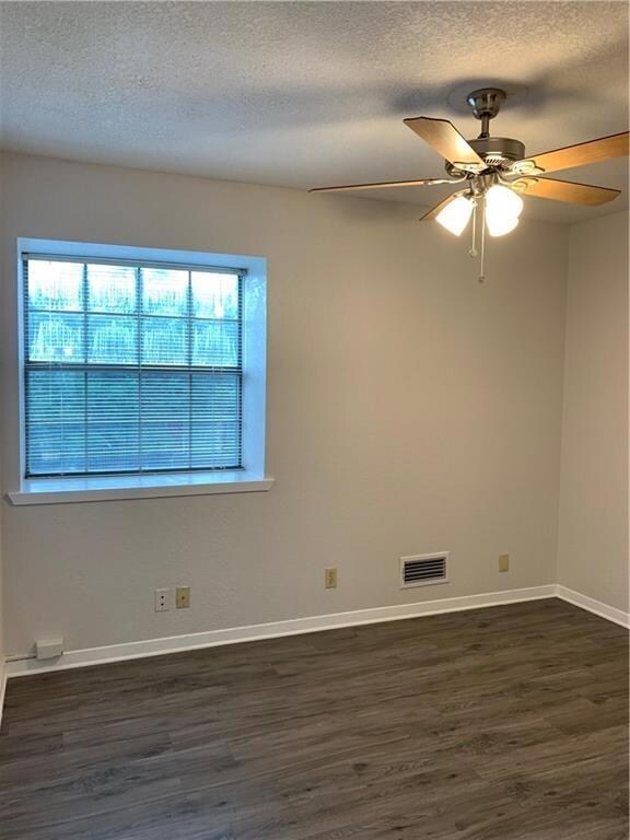 Spare room with dark wood finished floors, a text