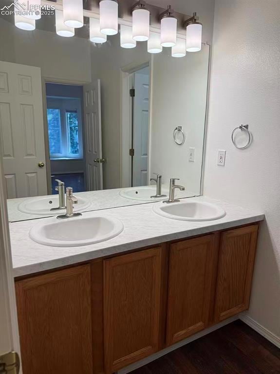 Bathroom featuring double vanity and dark wood-style flooring