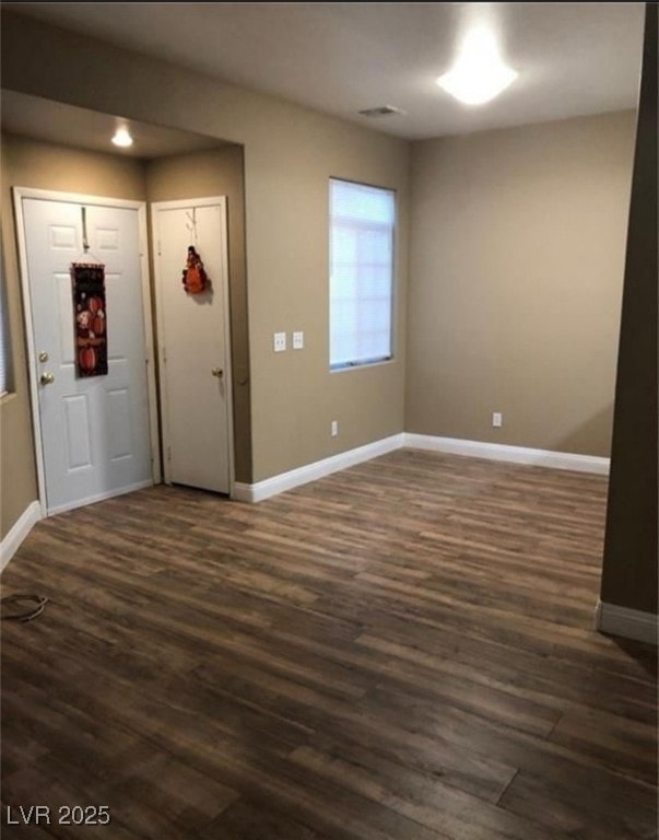 Foyer entrance with baseboards, dark wood-type flo