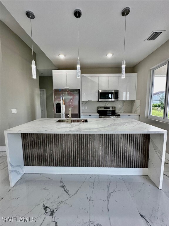 Kitchen with white cabinetry, stainless steel appl