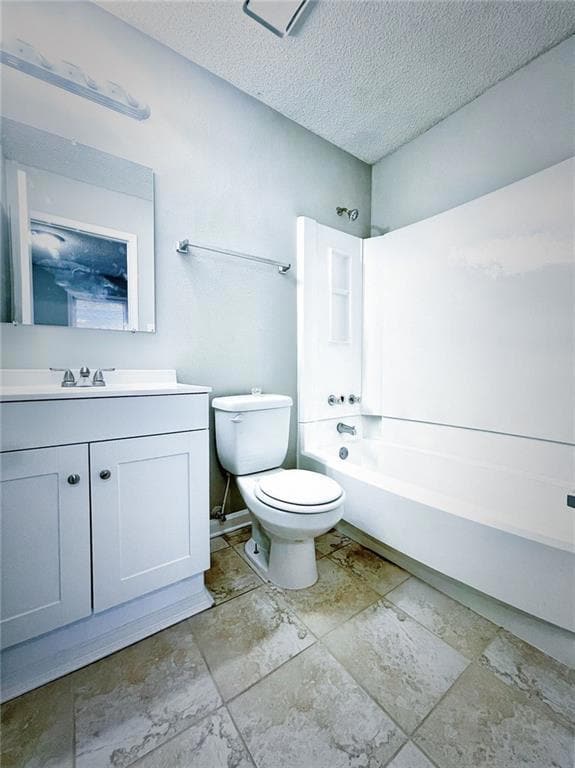 Full bathroom featuring toilet, vanity, a textured ceiling, and shower / bathtub combination