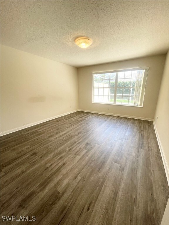 Unfurnished room with dark wood finished floors an