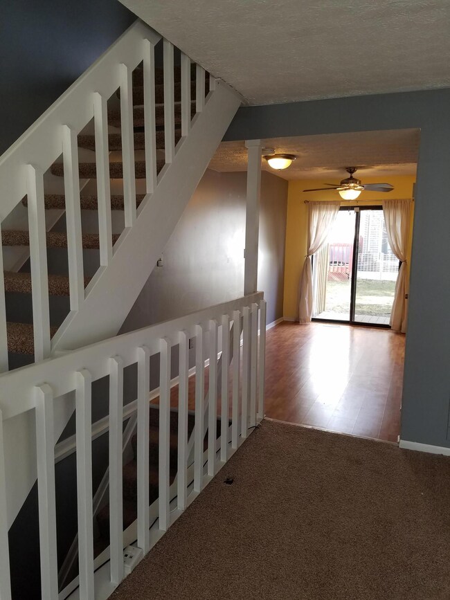 Family room white stairway & view of kit
