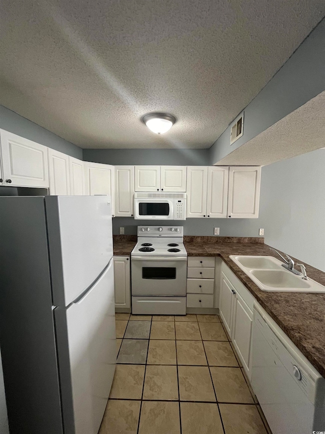 Kitchen with sink, light tile patterned flooring, 