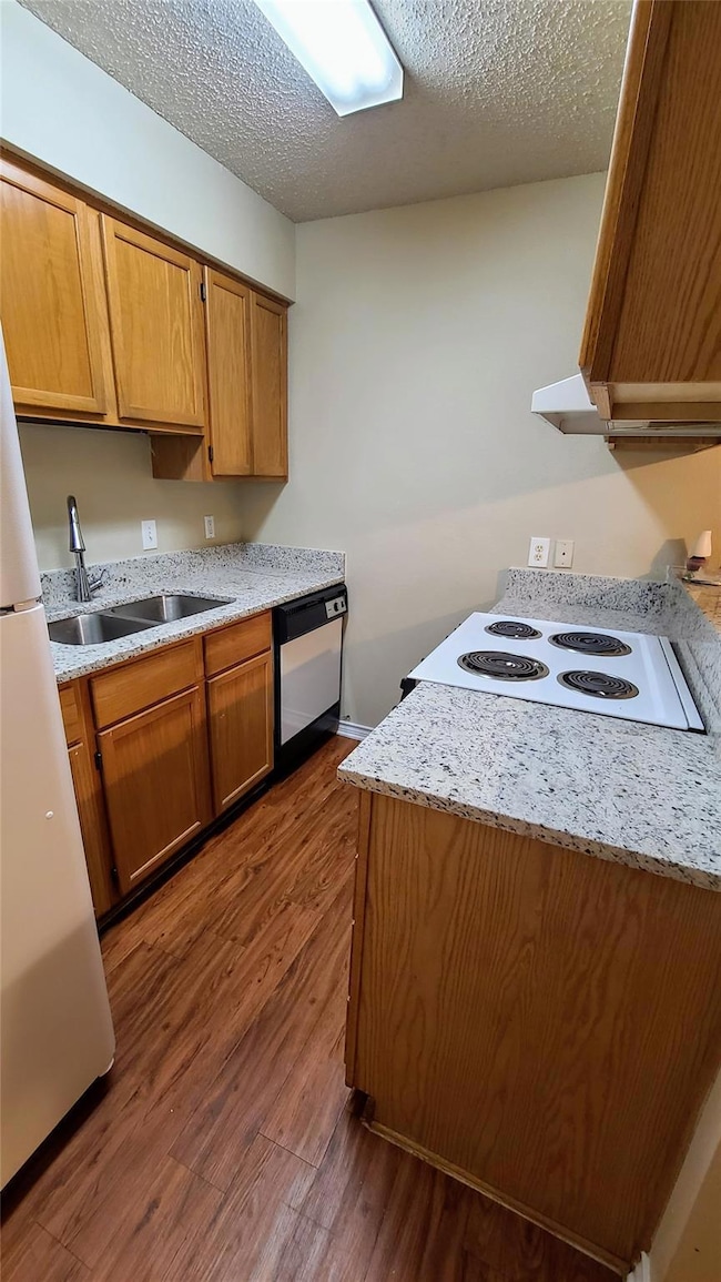 Kitchen with light countertops, a sink, dishwashi