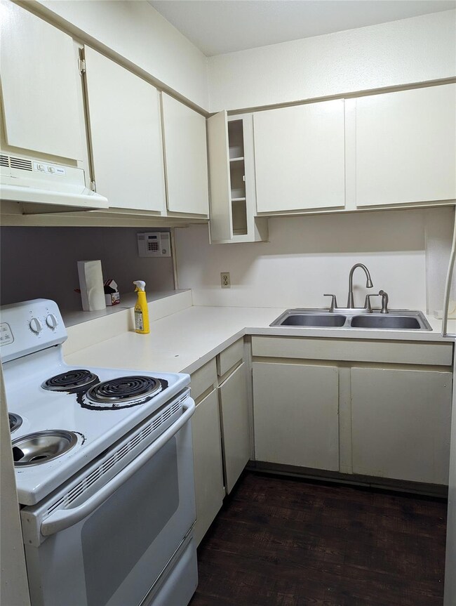 Kitchen featuring white cabinets, sink, white elec