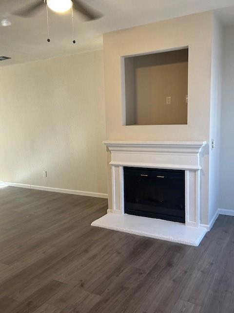 Unfurnished living room with baseboards, dark wood