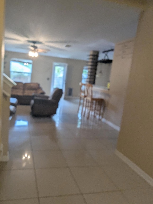 Hallway featuring tile patterned floors and baseboards