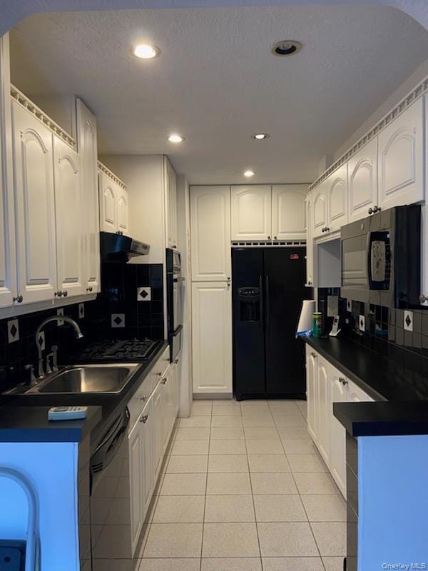 Kitchen featuring decorative backsplash, dark countertops, white cabinetry, a textured ceiling, and recessed lighting