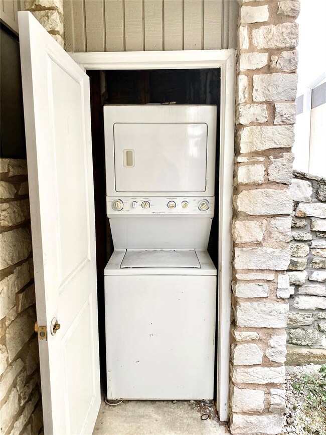 Laundry area featuring stacked washer and dryer a