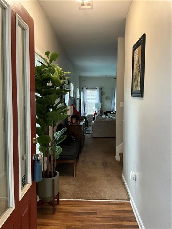 Hallway featuring wood finished floors and baseboards