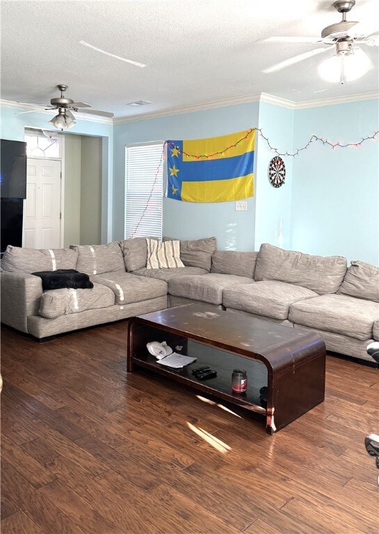 Living area featuring ceiling fan, ornamental molding, a textured ceiling, and wood finished floors