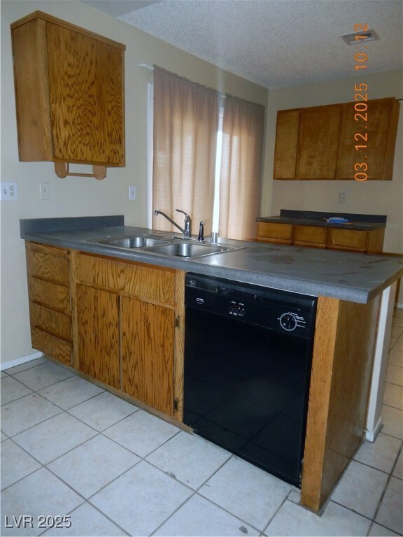 Kitchen with dark countertops, dishwasher, brown c
