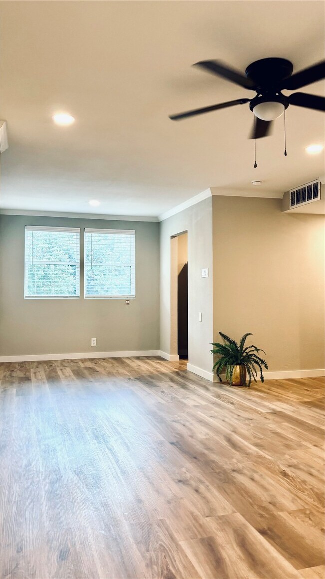 View of living room and dining room with wood finished floors, recessed lighting, and ornamental molding.