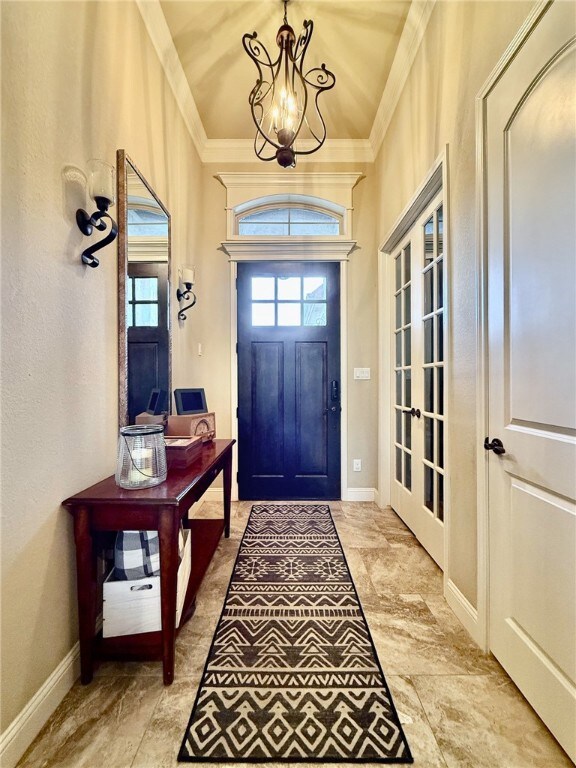 Foyer with a chandelier and ornamental molding