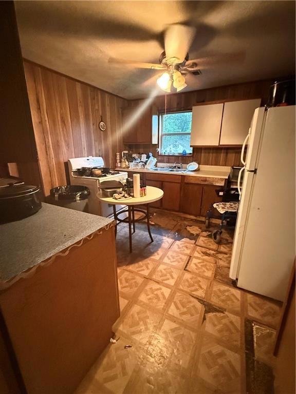 Kitchen featuring fridge, stove, light floors, woo