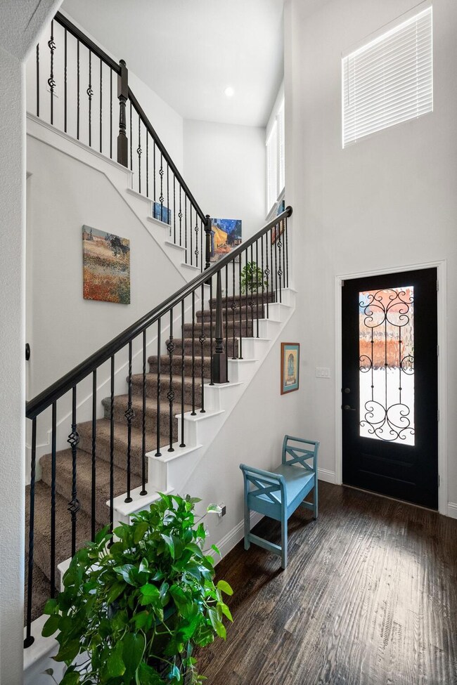 Front door view. Stair railing has pretty wrought 