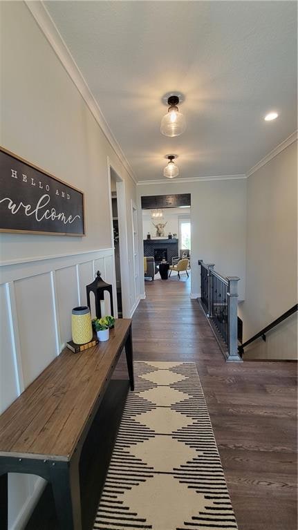 Hallway with ornamental molding and dark hardwood / wood-style flooring